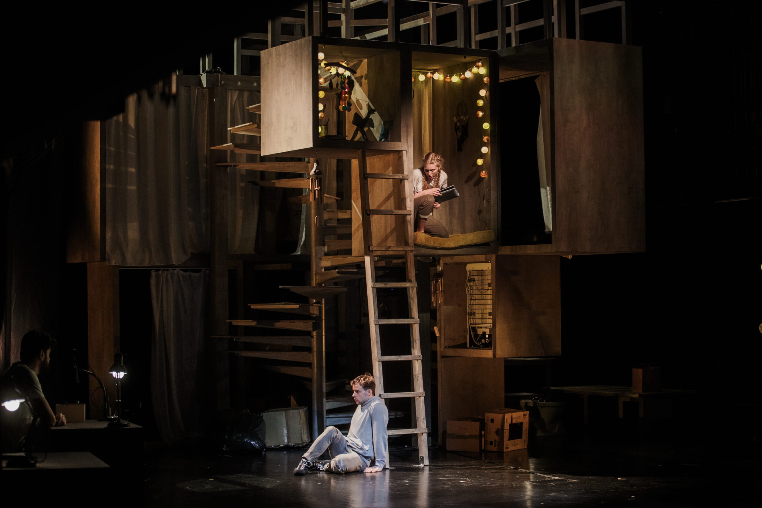 Stseen noortelavastusest "Luidrik". Trepi kõrval lavapõrandal istub Märten Metsaviir, üleval toakeses istub Emili Rohumaa.